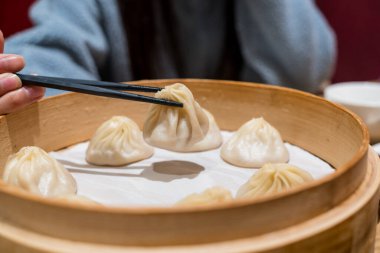 Buharda pişirilmiş Xiaolongbao geleneksel buhar sepetinde servis edilir.