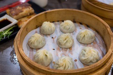 Buharda pişirilmiş Xiaolongbao geleneksel buhar sepetinde servis edilir.