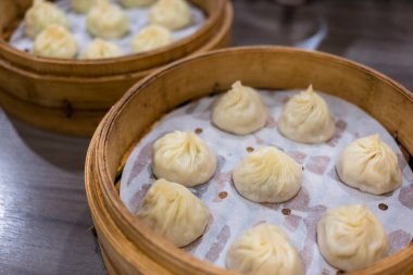 Buharda pişirilmiş Xiaolongbao geleneksel buhar sepetinde servis edilir.