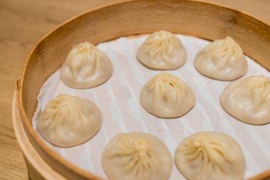 Buharda pişirilmiş Xiaolongbao geleneksel buhar sepetinde servis edilir.