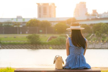 Nehir kenarındaki sandalyede oturan kadın.