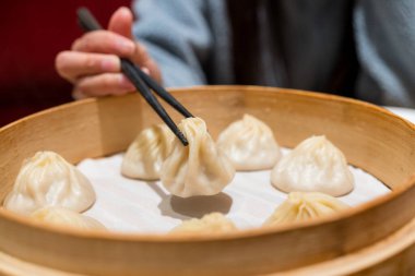Buharda pişirilmiş Xiaolongbao geleneksel buhar sepetinde servis edilir.