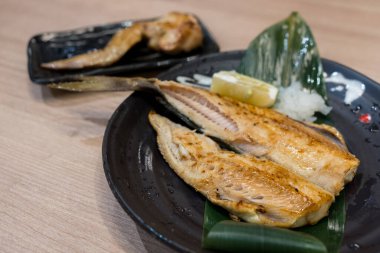 Japon restoranındaki tabakta ızgara balığı.