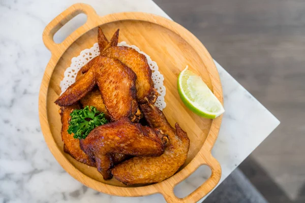 Deep fried chicken wing on wooden plate