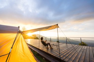 Kadınlar kampa gider ve gün batımında atıştırmalıklarla dışarıda otururlar.