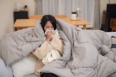 Kadın hastalanıyor ve evde hapşırıyor.
