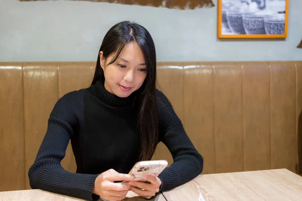 Woman use of mobile phone in restaurant