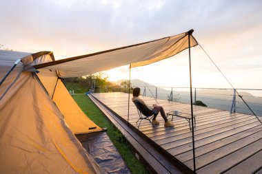 Kadın kampa gider ve günbatımının tadını çıkarır.