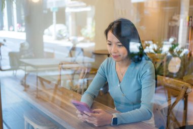 Kadınlar kahve dükkanında akıllı telefon kullanır.