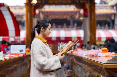 Asyalı kadın Çin tapınağında dua ediyor.
