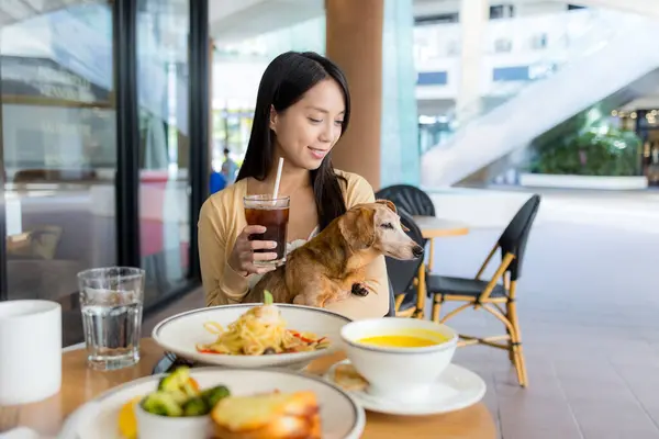 Woman go to restaurant with her dog in shopping center