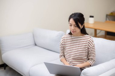 Kadın evde dizüstü bilgisayarda çalışıyor.