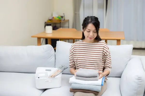 Woman fold with her blanket fabric towel at home after the laundry