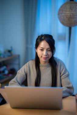 Kadın evde dizüstü bilgisayarda çalışıyor.