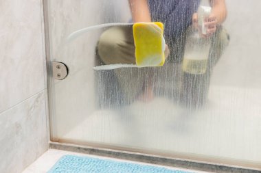 Eller pencereleri sünger ve deterjanla temizliyor.