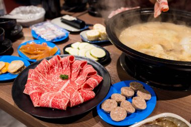 Masada bir sürü yemek olan sıcak bir tencere.