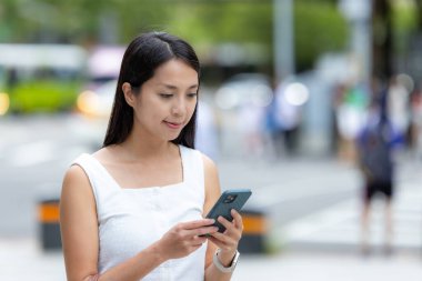 Kadın şehirde cep telefonu kullanıyor