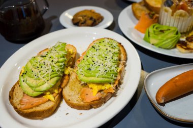 Somon ekmeğine dilimlenmiş avokado ve baharatlı ekmek.