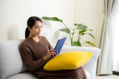 Ev hanımı evde tablet bilgisayarda çalışıyor.