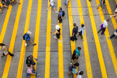 Hong Kong - 23 Haziran 2023: Karşıdan karşıya geçen insanların tepeden aşağı görüntüsü