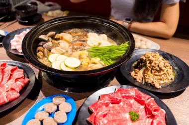 Masada bir sürü yemek olan sıcak bir tencere.