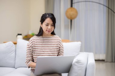 Evde dizüstü bilgisayarda çalışan bir kadın.