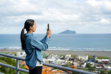 Turist kadın, Tayvan Yilan 'da fotoğraf çekmek için cep telefonu kullanıyor