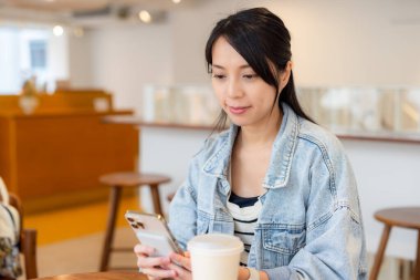 Kadınlar kahve dükkanında akıllı telefon kullanır.