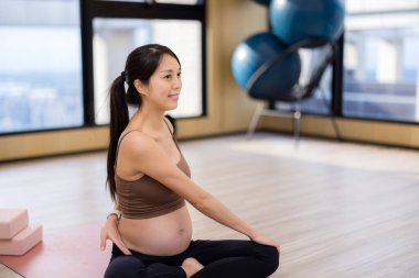 Asyalı hamile kadın yoga egzersizleri yapıyor.