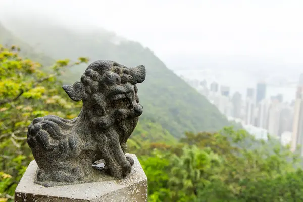 绿色背景的狮石雕像 图库照片