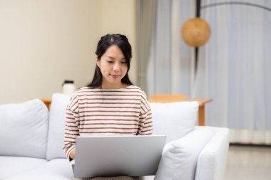 Ev hanımı evde dizüstü bilgisayarda çalışıyor.