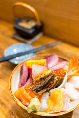 Çeşitli taze sashimi balıklı pilav kasesi.