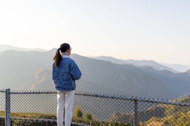 Kadınlar akşamları dağın üzerinden manzaranın tadını çıkarırlar.