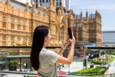 Turist kadın Macau 'da fotoğraf çekmek için cep telefonu kullanıyor.