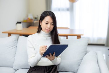 Kadın evde dijital kalemle tablet kullanıyor