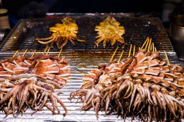 Izgara mürekkep balığı, sokak pazarındaki tezgahta satılıyor.