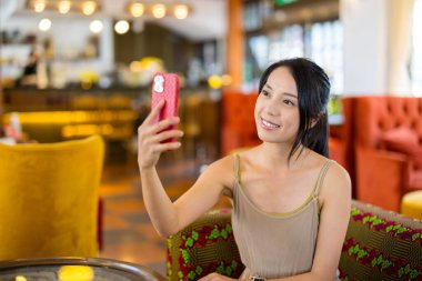 Kadınlar kafede selfie çekmek için cep telefonu kullanır.