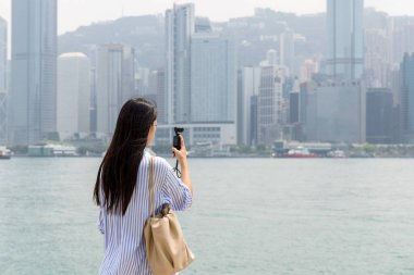 Turist kadın fotoğraf çekmek için Hong Kong 'da kamera kullanıyor.