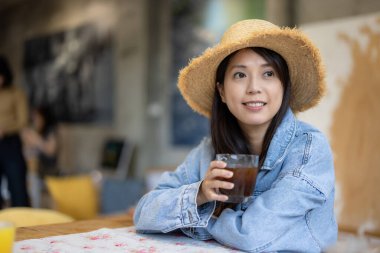 Kadın lokantada kahvesinin tadını çıkarıyor.