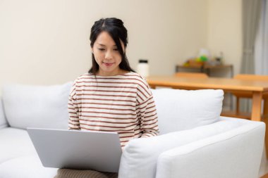 Kadın evde dizüstü bilgisayarda çalışıyor.