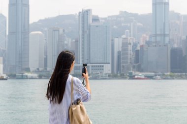 Turist kadın fotoğraf çekmek için Hong Kong 'da kamera kullanıyor.