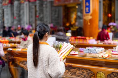 Asyalı kadın Çin tapınağında dua ediyor.