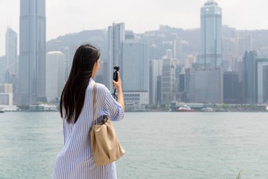 Turist kadın fotoğraf çekmek için Hong Kong 'da kamera kullanıyor.