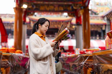 Asyalı kadın Çin tapınağında dua ediyor.