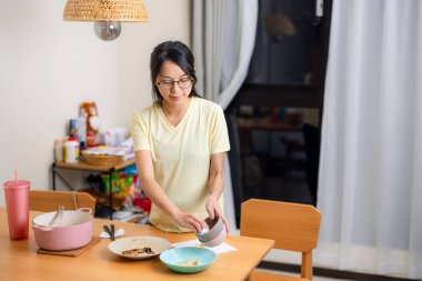 Hamile kadın akşam yemeğinden sonra masayı temizliyor.