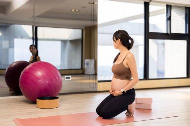 Hamile kadın antrenman için yoga stüdyosuna gidiyor. 