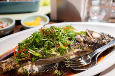 Çin restoranında taze soğan ve soya soslu haşlanmış balık.