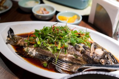 Çin restoranında taze soğan ve soya soslu haşlanmış balık.