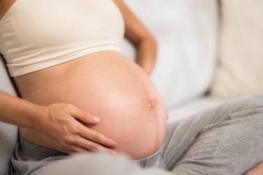 Hamile kadın karnına dokunuyor.