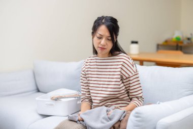 Ev hanımı evde çalıştığı için stres hissediyor, giysileri katlıyor.